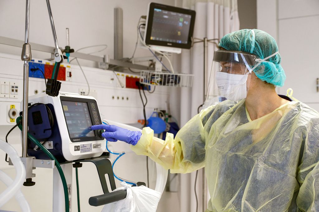 Patient on ventilator in ICU with monitoring equipment